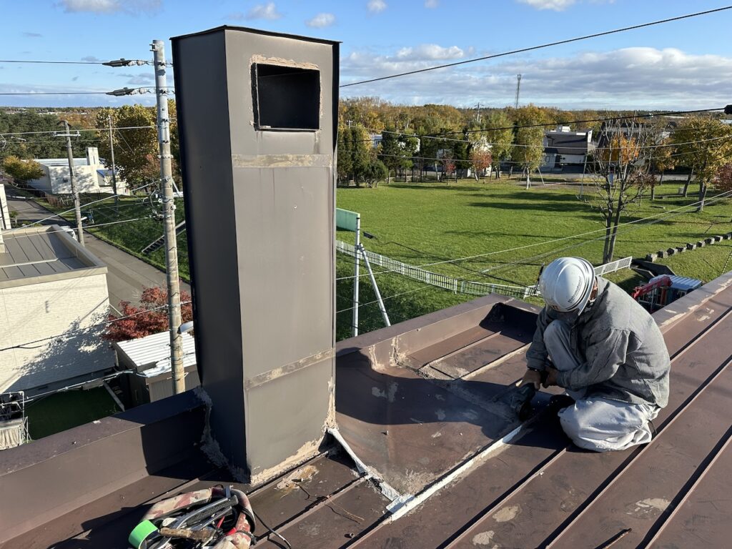 劣化した既存板金屋根とコーキングを撤去している様子｜無落雪屋根全面改修工事の初期工程