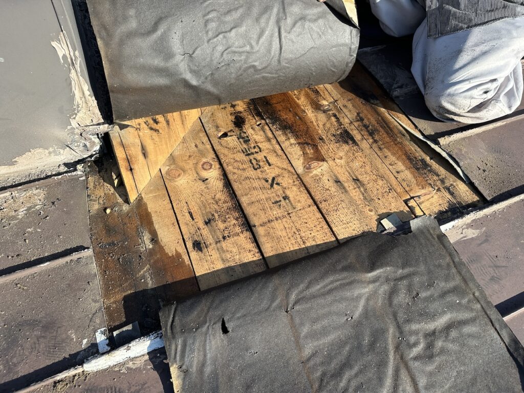 劣化した屋根下地の状態を確認している様子｜無落雪屋根全面改修工事の初期工程