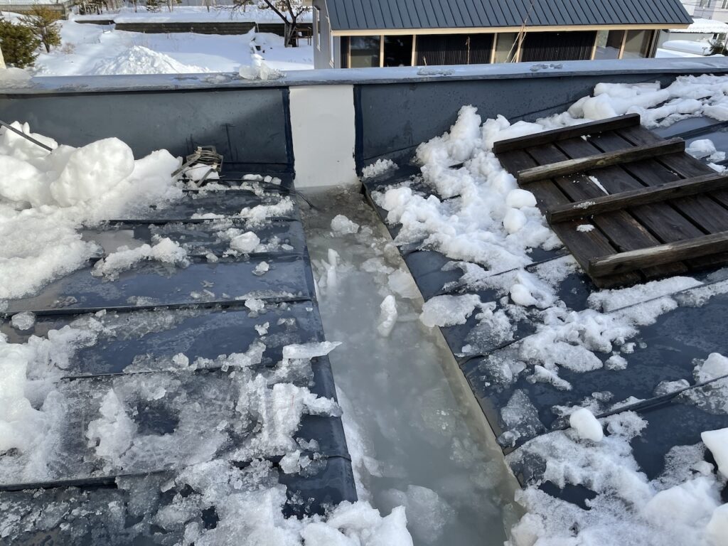 既存が上がり一気に屋根の雪が溶けてスノーダクトが溢れる様子